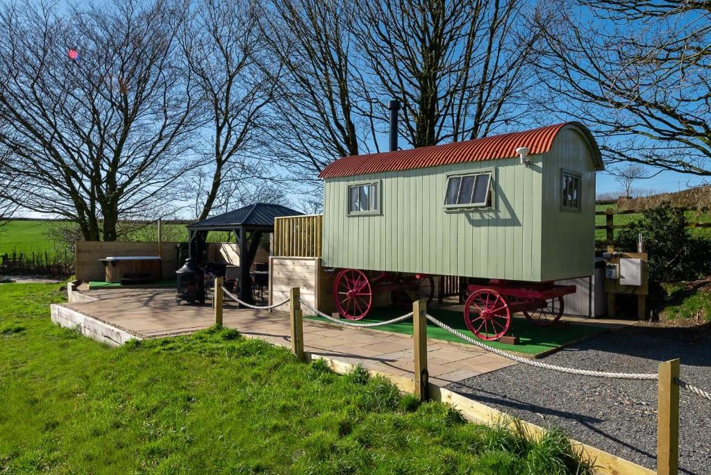 un pequeño vagón de tren verde expuesto en un parque en The Shepherd's Shed at Accott Manor, 