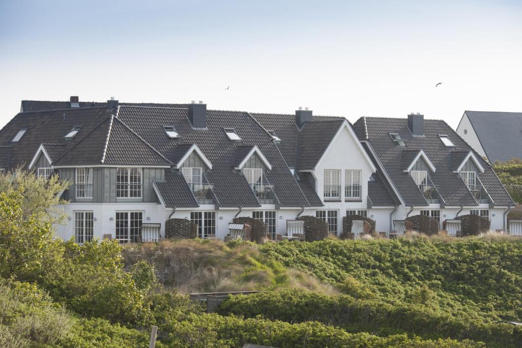 a row of white houses with black roofs at ApartHotel Seepferdchen in Hörnum