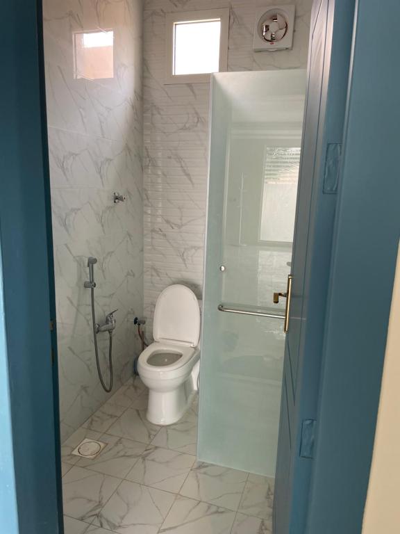 a bathroom with a white toilet and a shower at شالية السحاب in Al Ḩazm