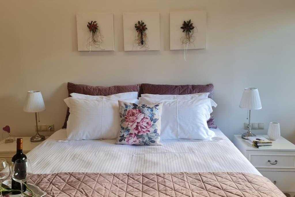 a bed with white pillows and two pictures on the wall at Luxury apartment in the heart of the city in Chania Town