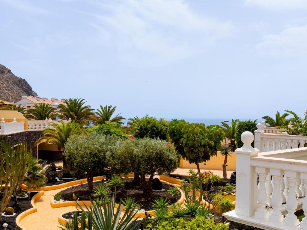 een balkon met uitzicht op de tuin van een resort bij 9 Parque Tropical Apartamento Los Cristianos in Los Cristianos