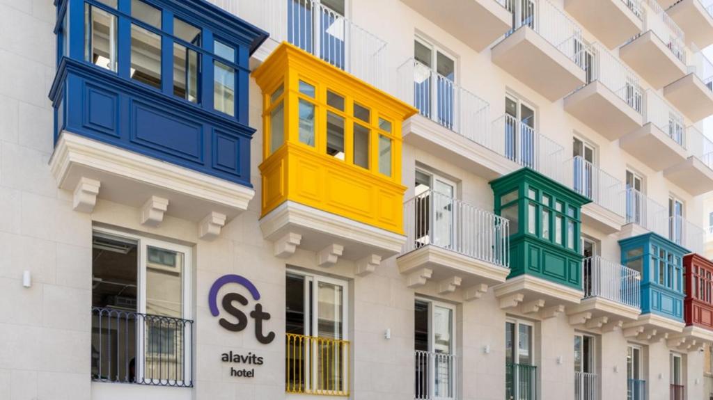 a building with colorful balconies on the side of it at Alavits Hotel by ST Hotels in Il-Gżira