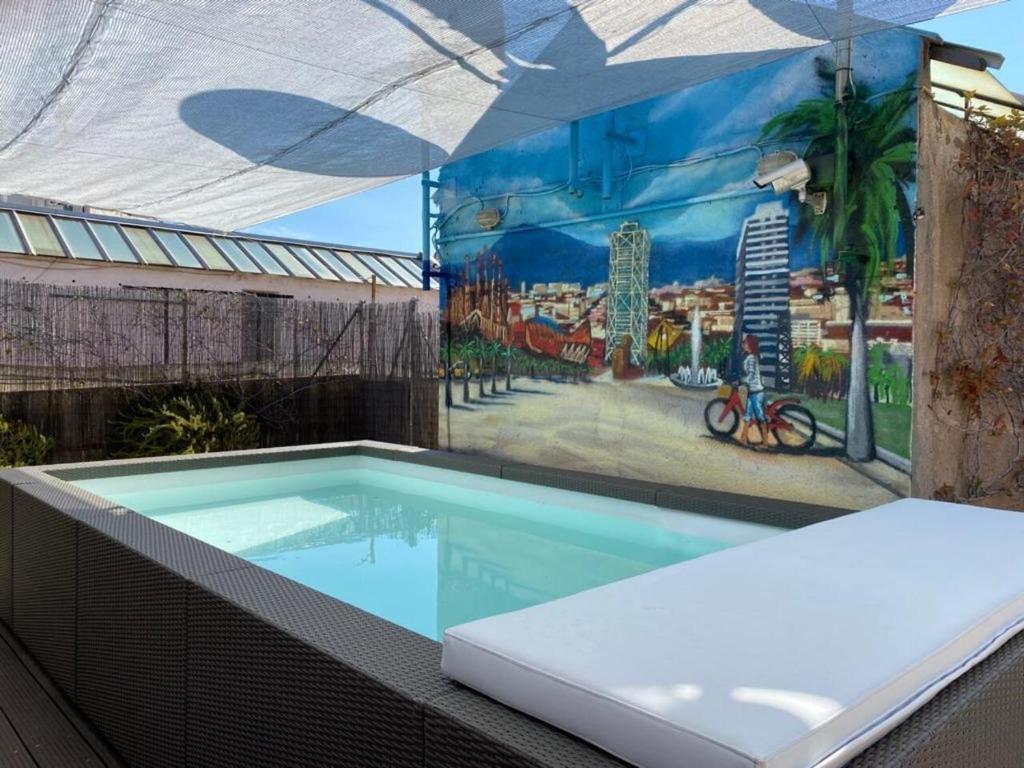 una piscina con un mural en el lateral de un edificio en Happy People Gaudi Sant Pau Apartments, en Barcelona