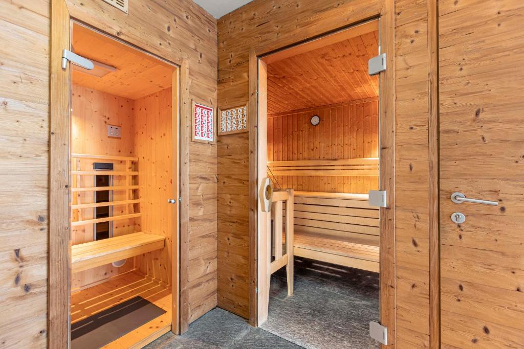 sauna z drewnianymi ścianami i drewnianymi drzwiami w obiekcie Tauernresidence Radstadt by ALPS RESORTS w mieście Radstadt