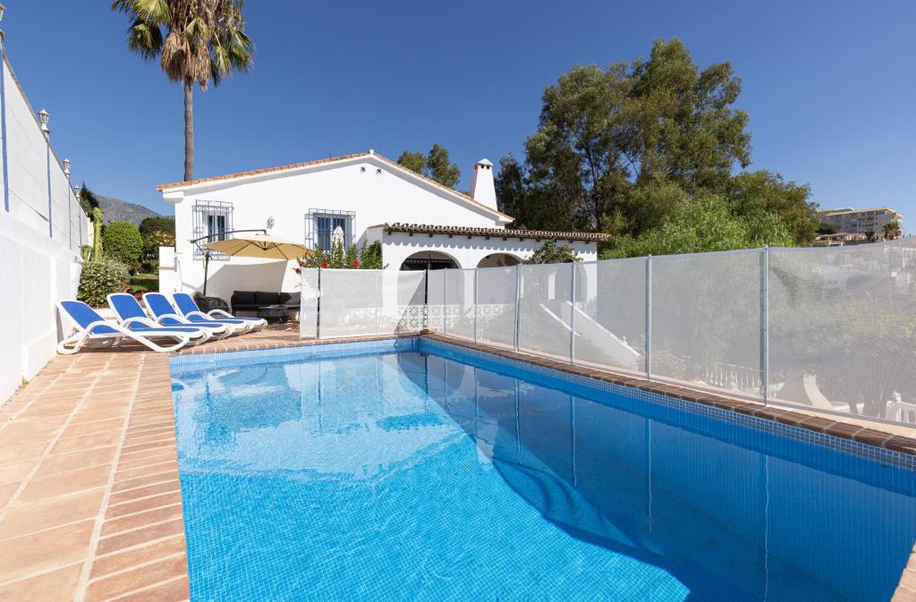 una piscina di fronte a una casa di 089 Andalusian Style 3 Bed Villa with Office and Private Pool a Fuengirola