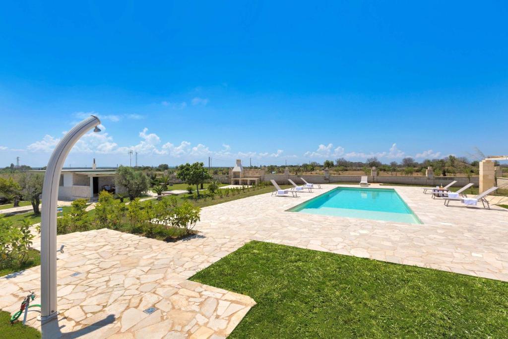 a swimming pool in a yard with chairs and a pole at Villetta Paola by BarbarHouse in Borgagne