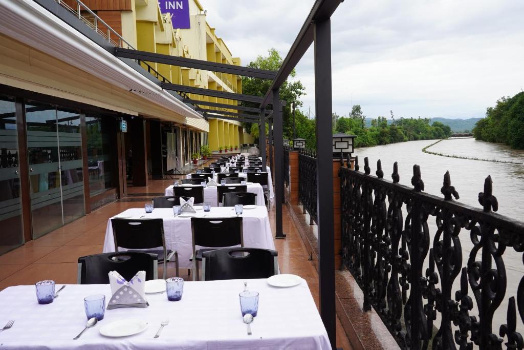 a row of tables on the balcony of a restaurant at Comfort Inn Coral River in Mādhopur