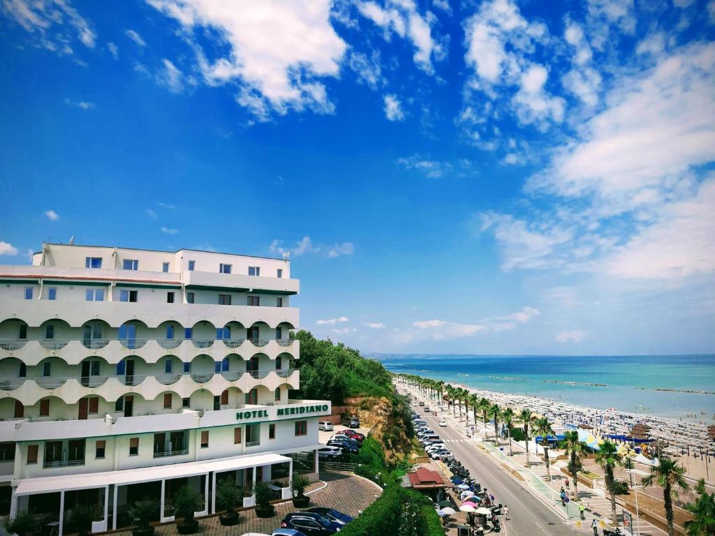 un hôtel sur la plage avec l'océan en arrière-plan dans l'établissement Hotel Meridiano, à Termoli