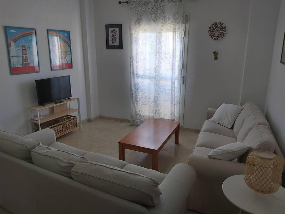 a living room with two couches and a television at Ático en Rota, junto a la playa in Rota