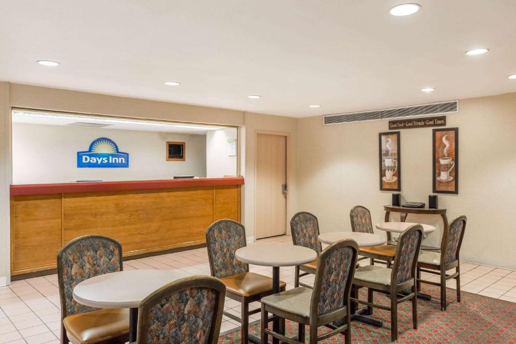 a waiting room with tables and chairs at Days Inn by Wyndham West Des Moines - Clive in Clive