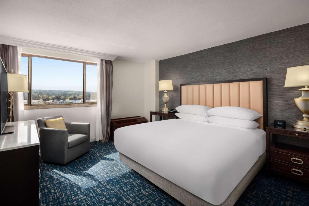 una camera d'albergo con un grande letto e una sedia di Hilton Concord a Concord