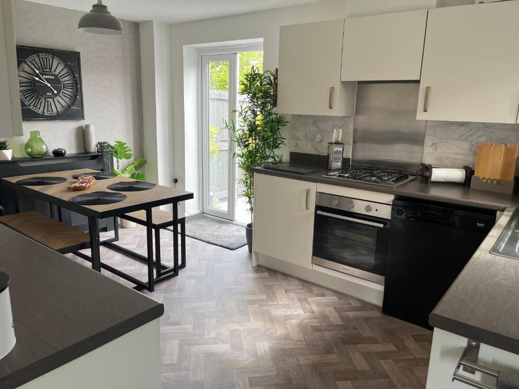 cocina con mesa y fogones horno superior en Lovely 3 bed house near Anfield Stadium with private parking and garden Guests must be 25 years or over to make a booking en Liverpool
