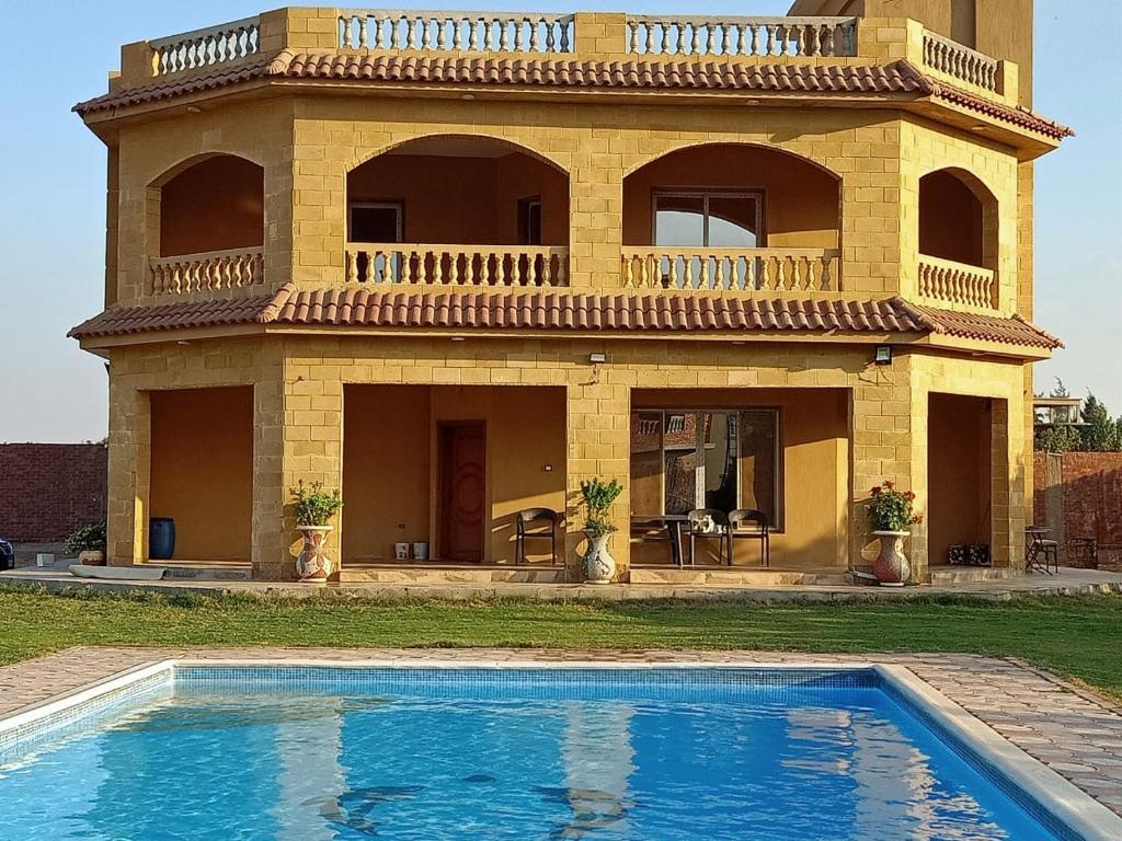 een huis met een zwembad ervoor bij فيلا للايجار في كمبوند سمر قند in El-Qaṭṭa