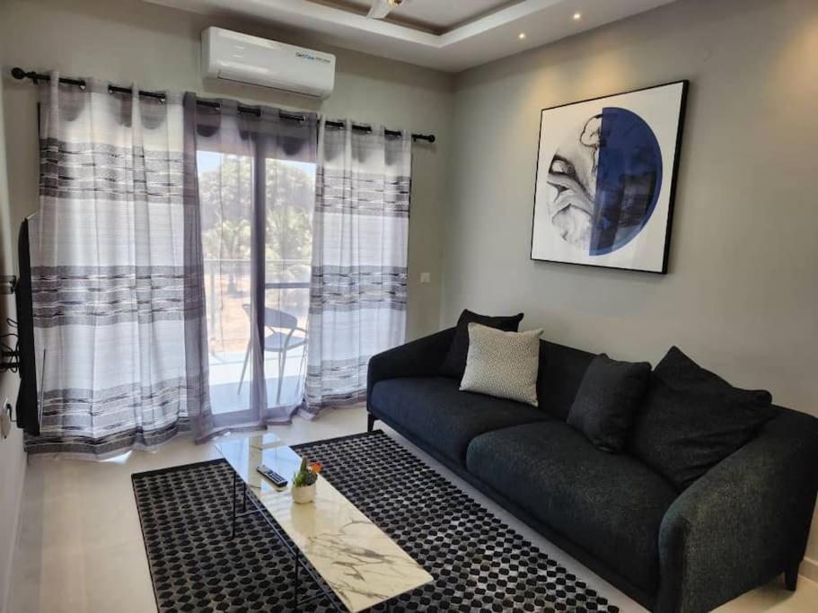 a living room with a black couch and windows at Elegant 1 bedroom apartment at Aquaview in Bathurst