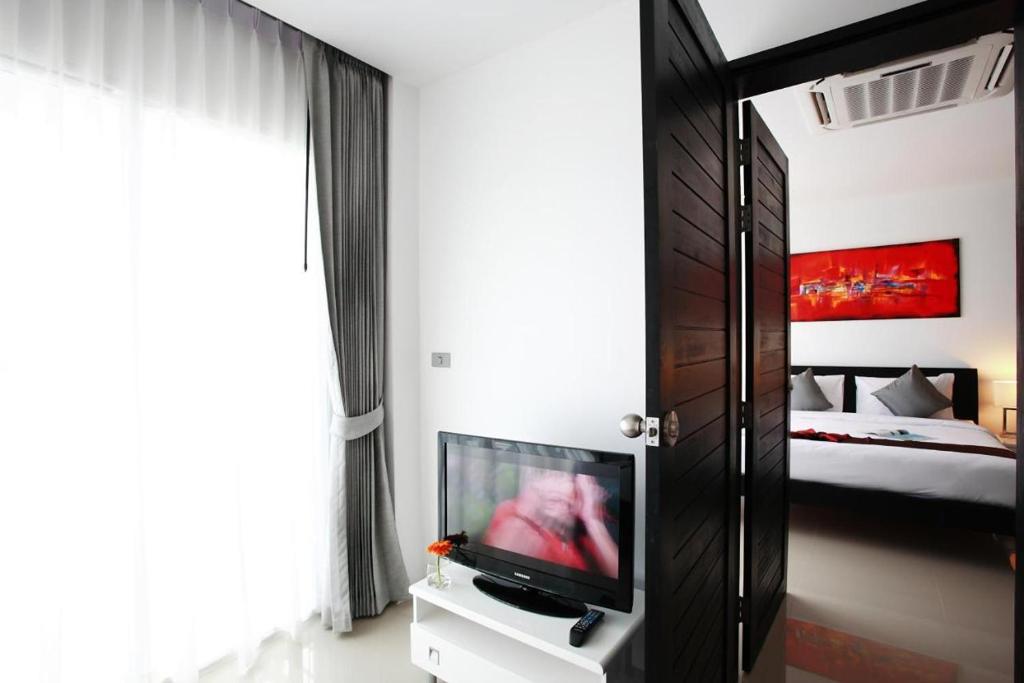 Postel nebo postele na pokoji v ubytování One World One Home Naiharn Hotel