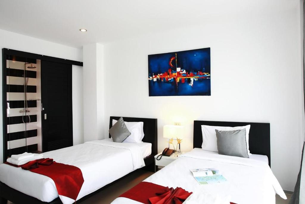 Postel nebo postele na pokoji v ubytování One World One Home Naiharn Hotel