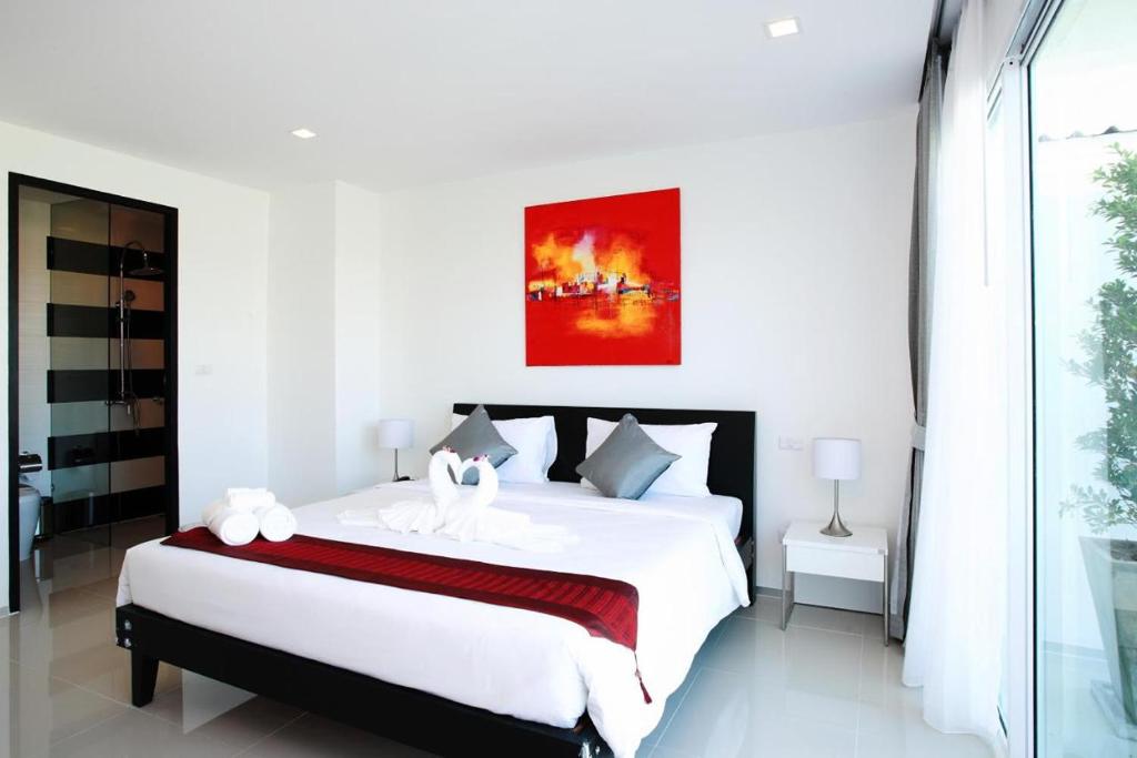 Postel nebo postele na pokoji v ubytování One World One Home Naiharn Hotel