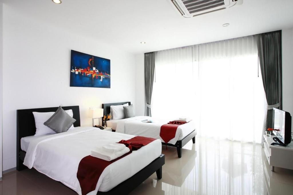 Postel nebo postele na pokoji v ubytování One World One Home Naiharn Hotel
