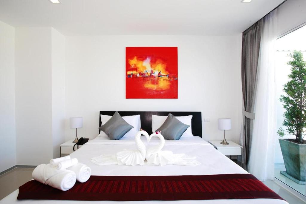 Postel nebo postele na pokoji v ubytování One World One Home Naiharn Hotel