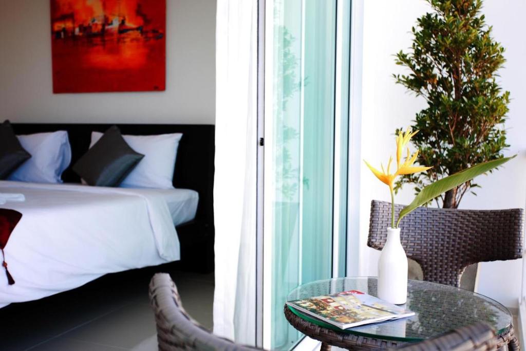 Postel nebo postele na pokoji v ubytování One World One Home Naiharn Hotel