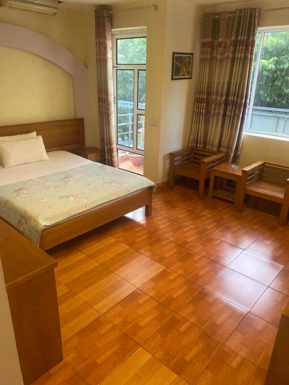 a bedroom with a bed and a wooden floor at Nhà Nghỉ Thu Hiền in Lao Cai