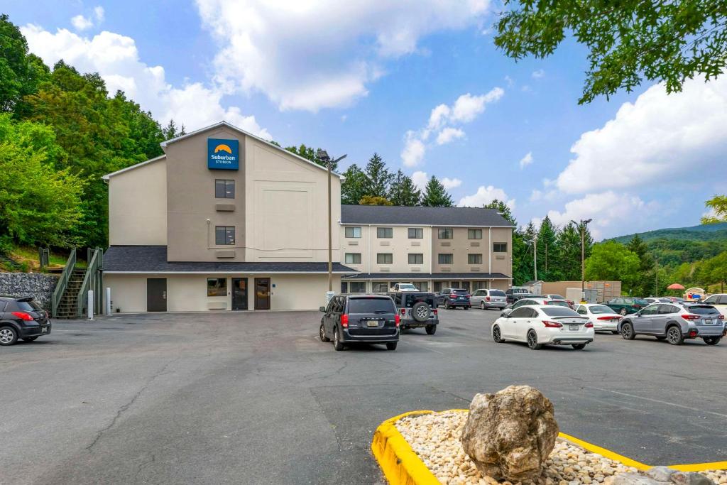 a large building with cars parked in a parking lot at Suburban Studios LaVale - Cumberland in La Vale