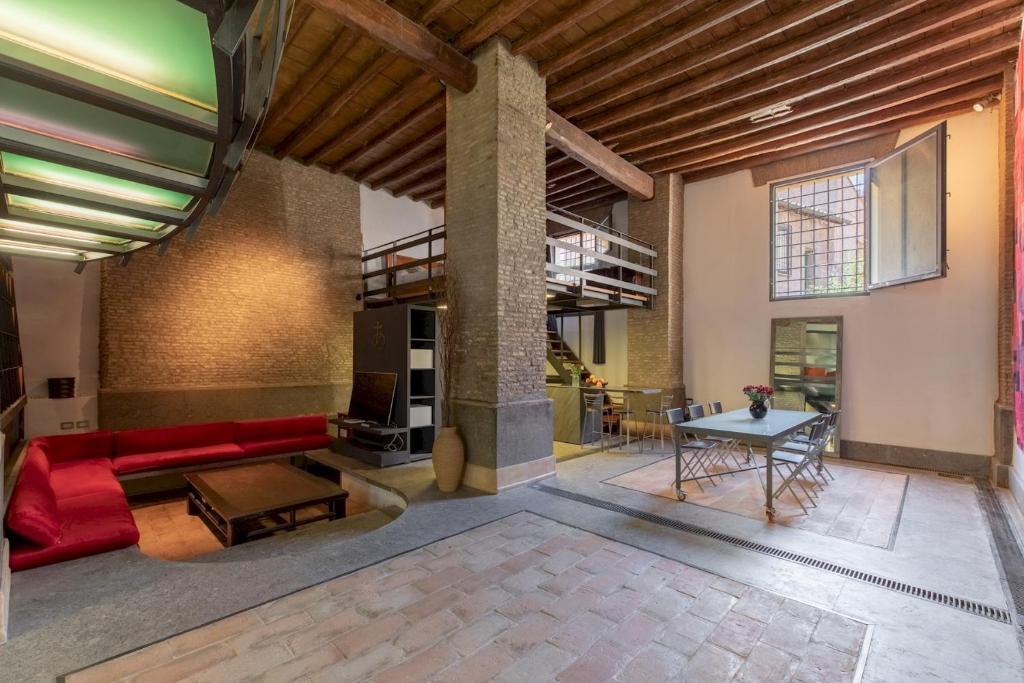 a living room with a red couch and a table at Santa Cecilia Loft in Rome