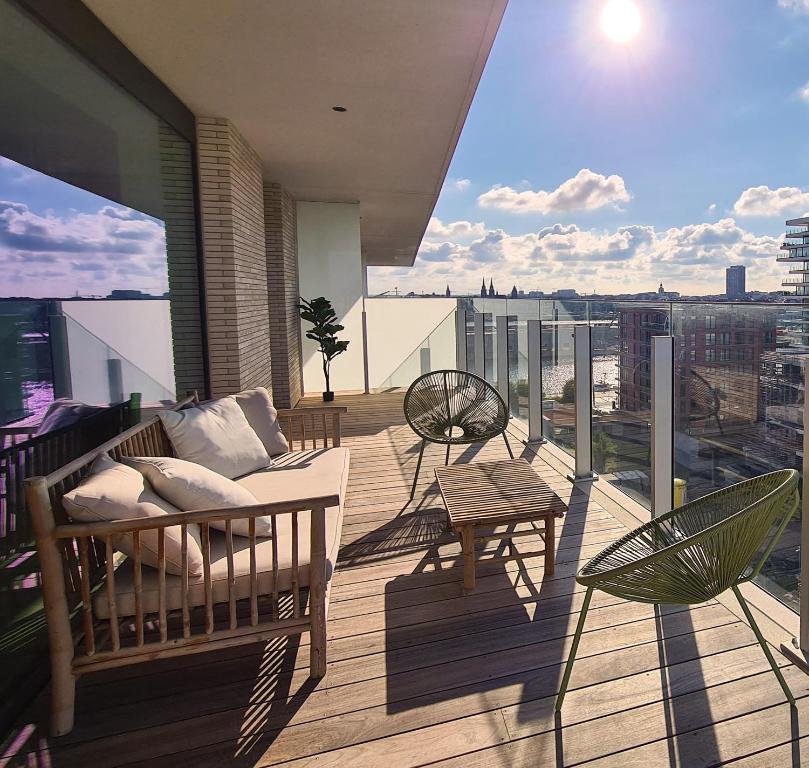 un balcone con divano e sedie in un edificio di Central Park Tower Sea View Residence with pool and gym a Ostenda