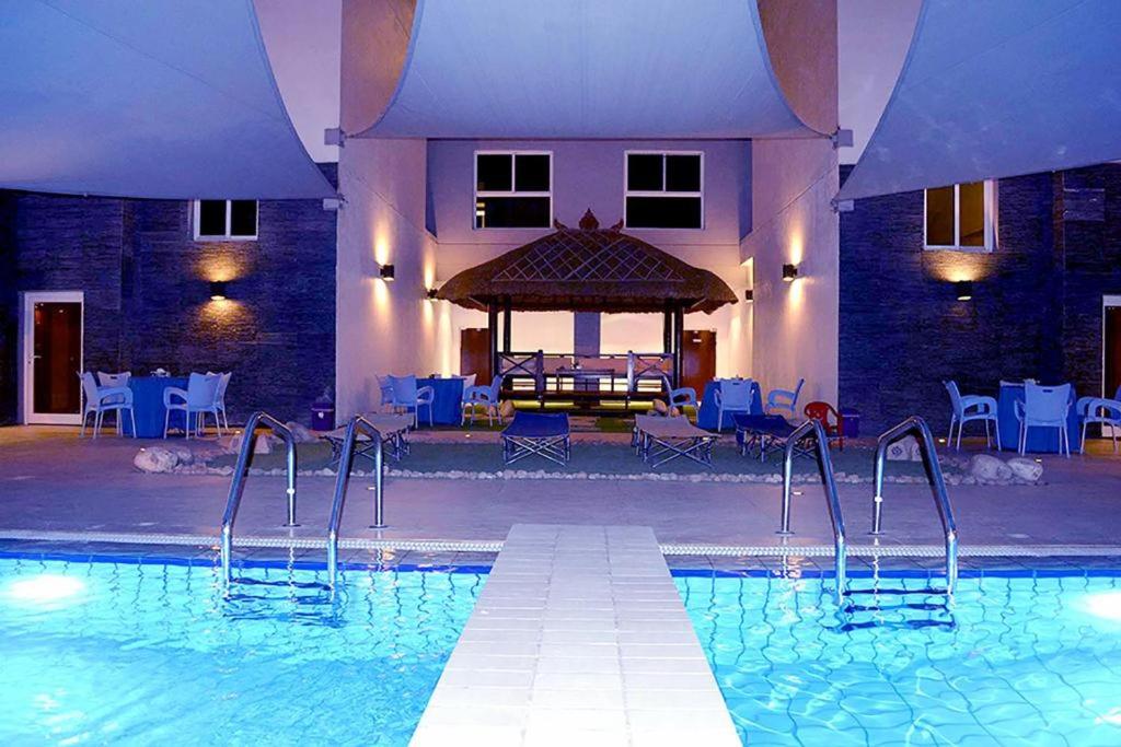 a swimming pool with a gazebo in a building at Hotel Leaders Plaza Mahboula in Kuwait