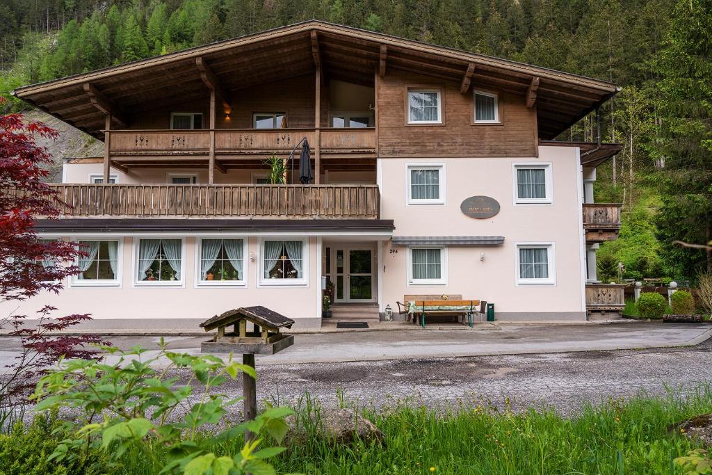 a large white building with a wooden roof at Appartements Laura in Mayrhofen