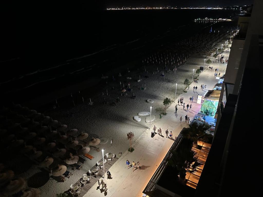 eine Gruppe von Menschen, die nachts am Strand spazieren in der Unterkunft Luxury Penthouse Shkembi Kavajes in Durrës
