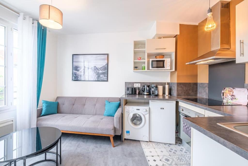 cocina y sala de estar con sofá y lavadora en T2 calme proche hyper centre, en Limoges