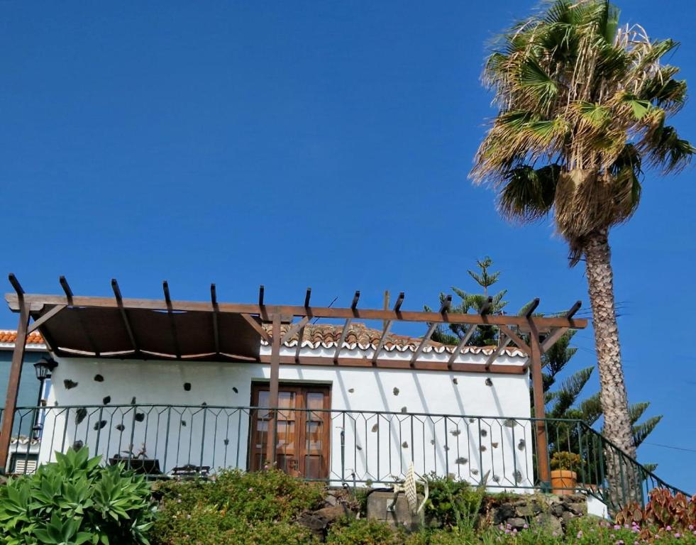 una casa blanca con una palmera delante de ella en Casita Canaria con Vista, en Breña Baja