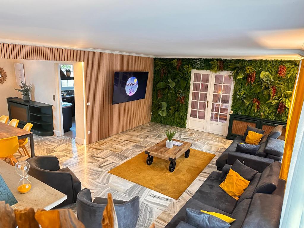 un salon avec un canapé et une table dans l'établissement Villa avec pièce Billard style Ranch US, à Saint-Fargeau-Ponthierry