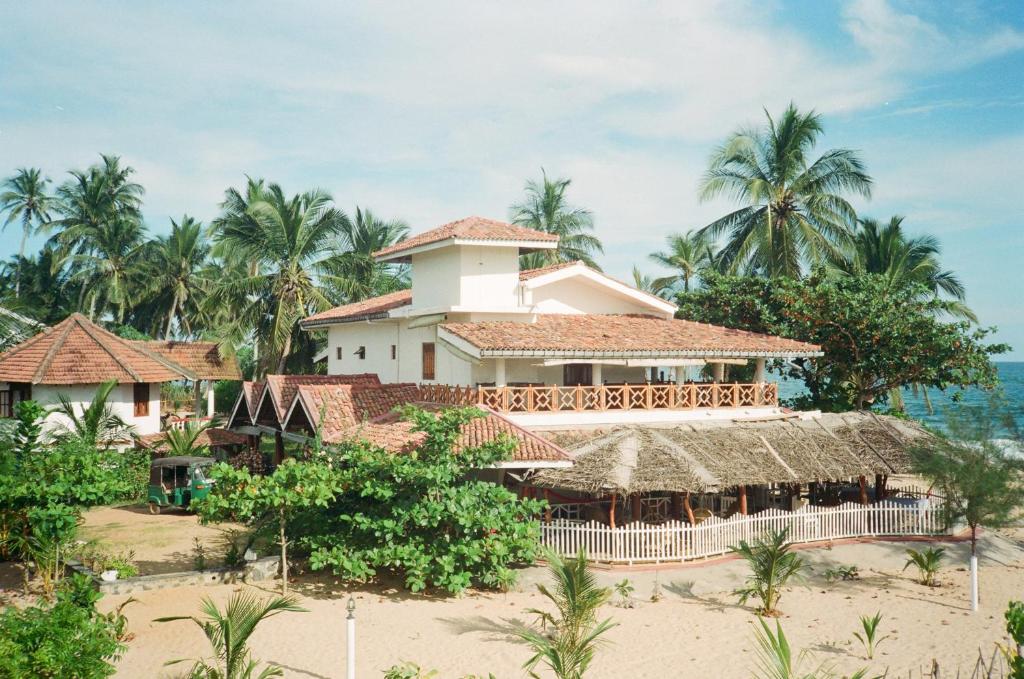 a resort on the beach in front of the ocean at Ibisbird Beach Bungalow in Tangalle