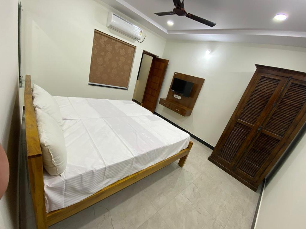 a bedroom with a bed and a television in it at Magnolia Villa Luxury 3 Bedroom Apartments in Visakhapatnam