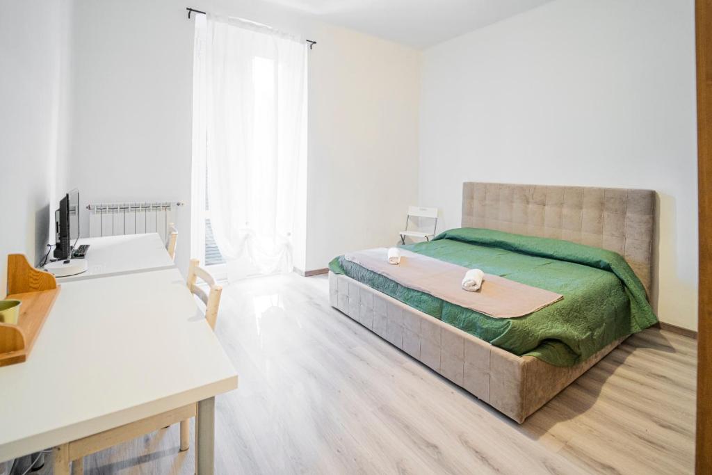 sypialnia z dużym łóżkiem i zielonym kocem w obiekcie Appartamento Genova,400m dal San Martino w Genui