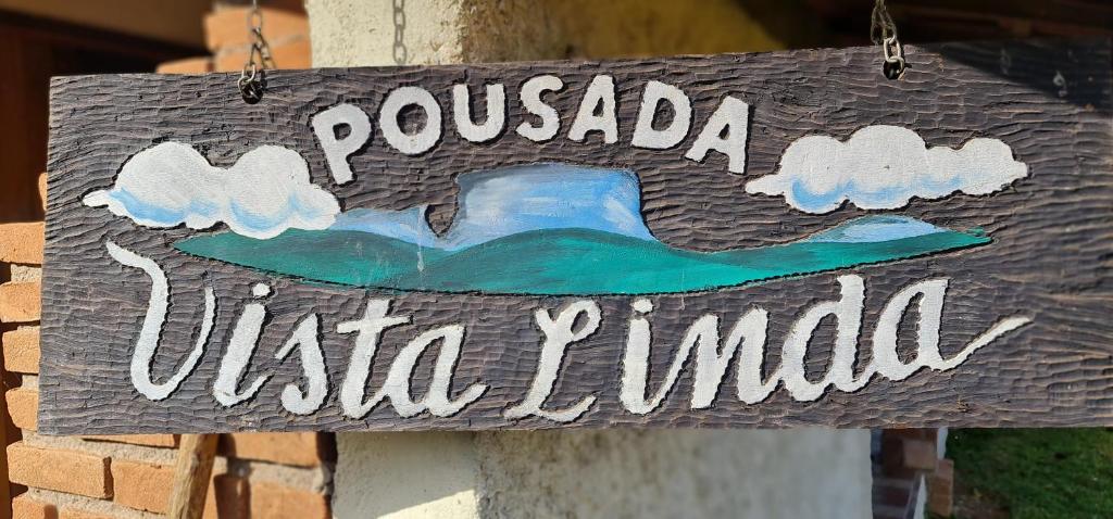 a wooden sign that reads pucadaidaida junilla at Pousada VISTA LINDA in São Bento do Sapucaí