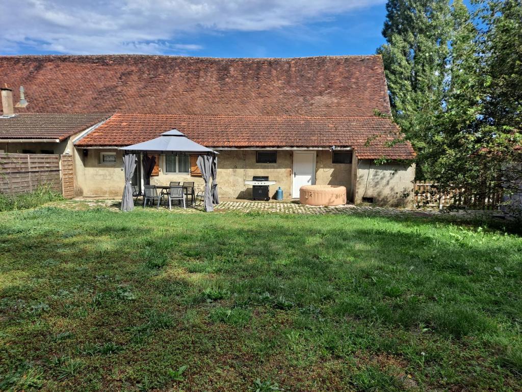une vieille maison avec une table et des chaises dans une cour dans l'établissement Les lutins rêveurs, à Montagny-près-Louhans