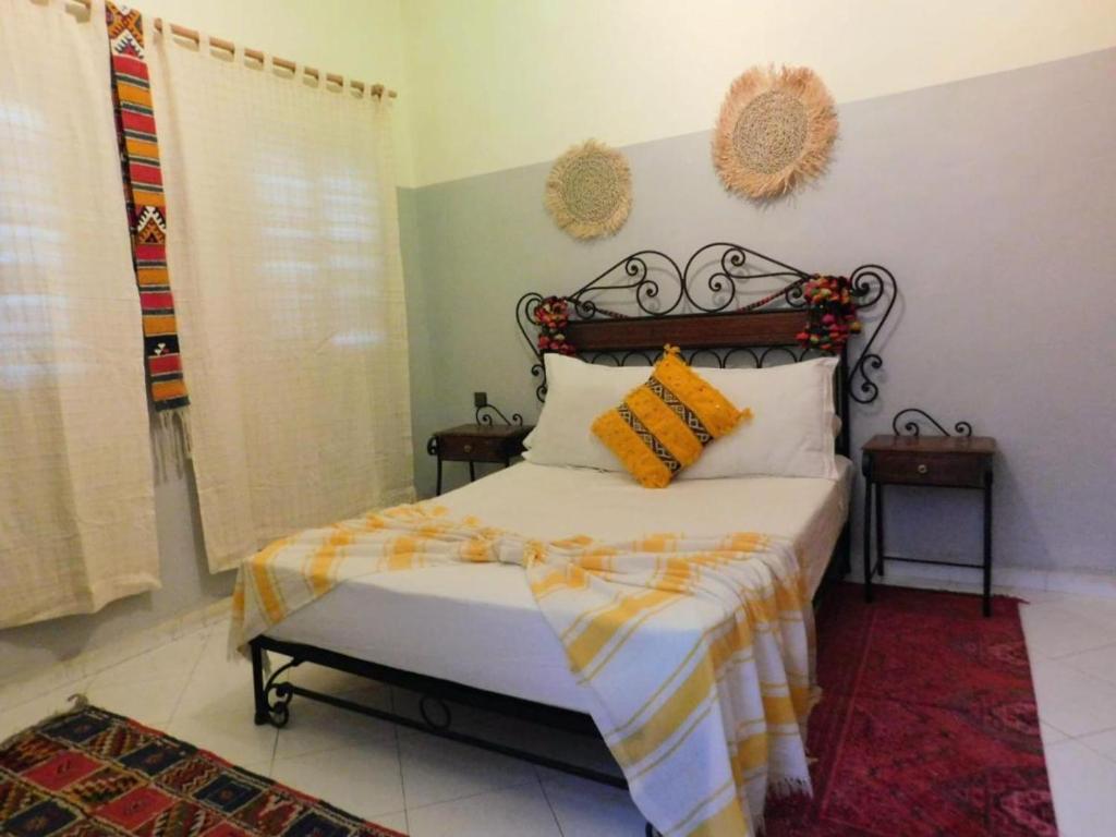 a bedroom with a bed with orange and yellow pillows at APPART AIGLE HOTEL in Ouarzazate