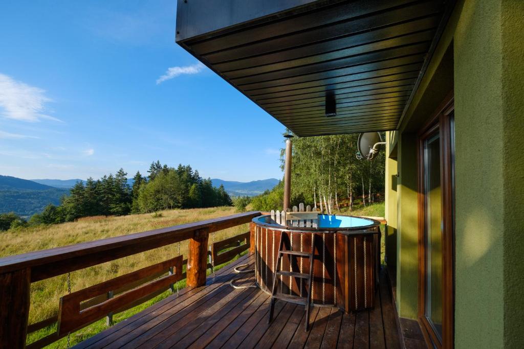 een terras met een tafel en stoelen op een huis bij Przystanek Madejowa in Jeleśnia