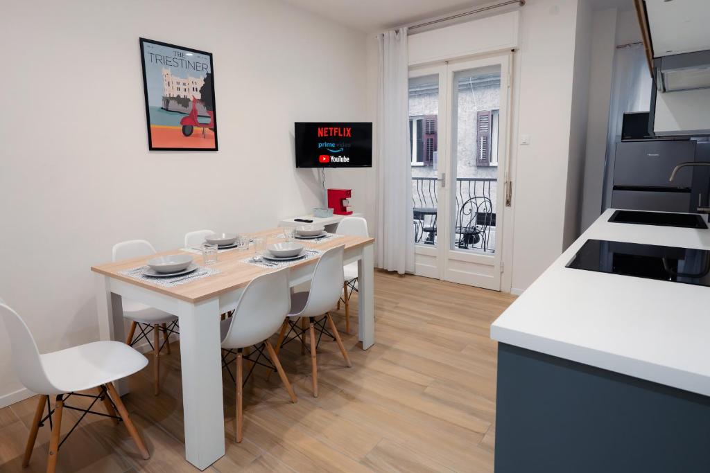 een keuken en eetkamer met een tafel en stoelen bij [Centro Storico] Moderno Trilocale con Balcone in Trieste