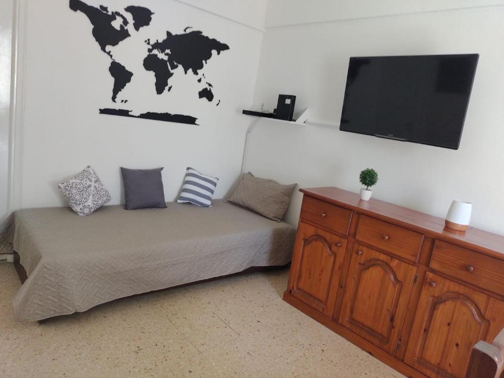 Habitación con cama y TV de pantalla plana. en Dpto Serafina en Mar del Plata