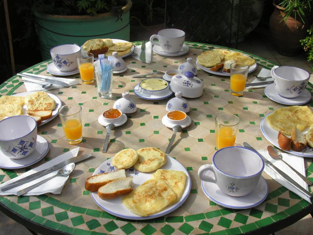 a table with plates of food and cups of orange juice at Appartement agréable avec 2 très belles terrasses au coeur de Rabat in Rabat