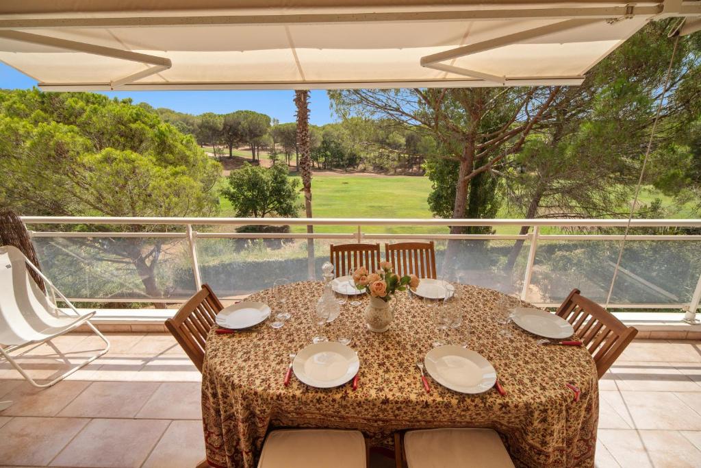 una mesa y sillas en un patio con vistas en Le 11 - Appt climatisé avec piscine partagée, en Saint-Raphaël