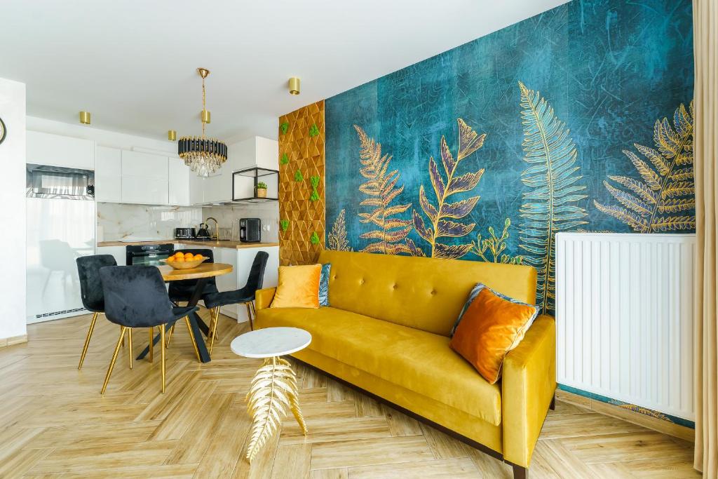 uma sala de estar com um sofá amarelo e uma cozinha em Mia Mare Premium Apartment by Perłowa Przystań Rent em Kolobrzeg