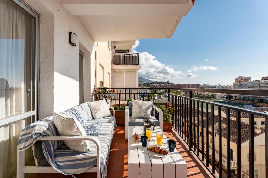 a balcony with a couch and a coffee table at Apartamento Arco Iris in Fuengirola