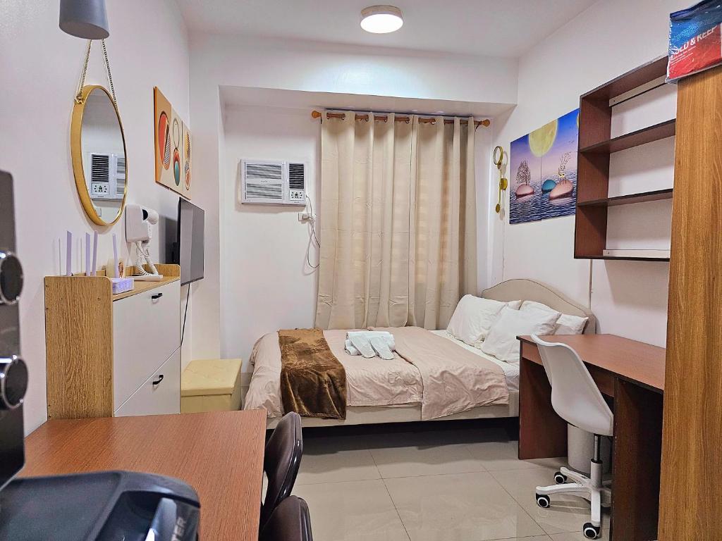 a hospital room with a bed and a desk at Acellyne Suites at Green 2 Residences with Netflix! in Dasmariñas