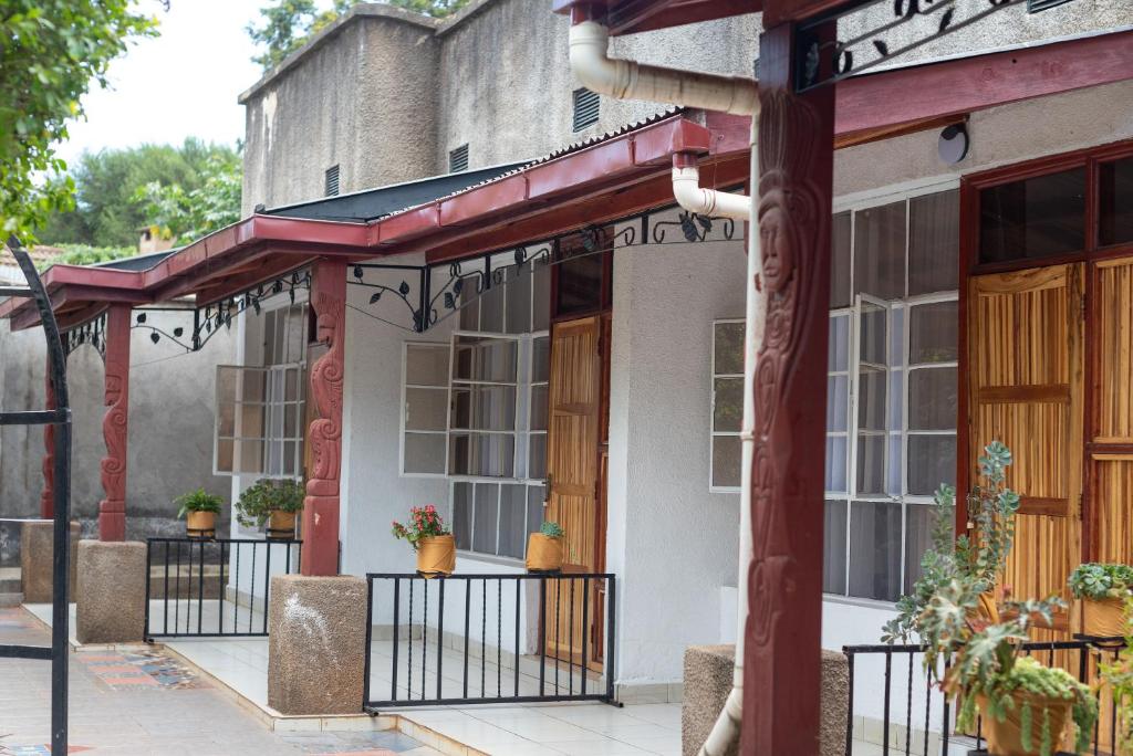 un bâtiment avec une terrasse couverte agrémentée de plantes en pot dans l'établissement VIJIJI HOTEL & CONFERENCE, à Eldoret