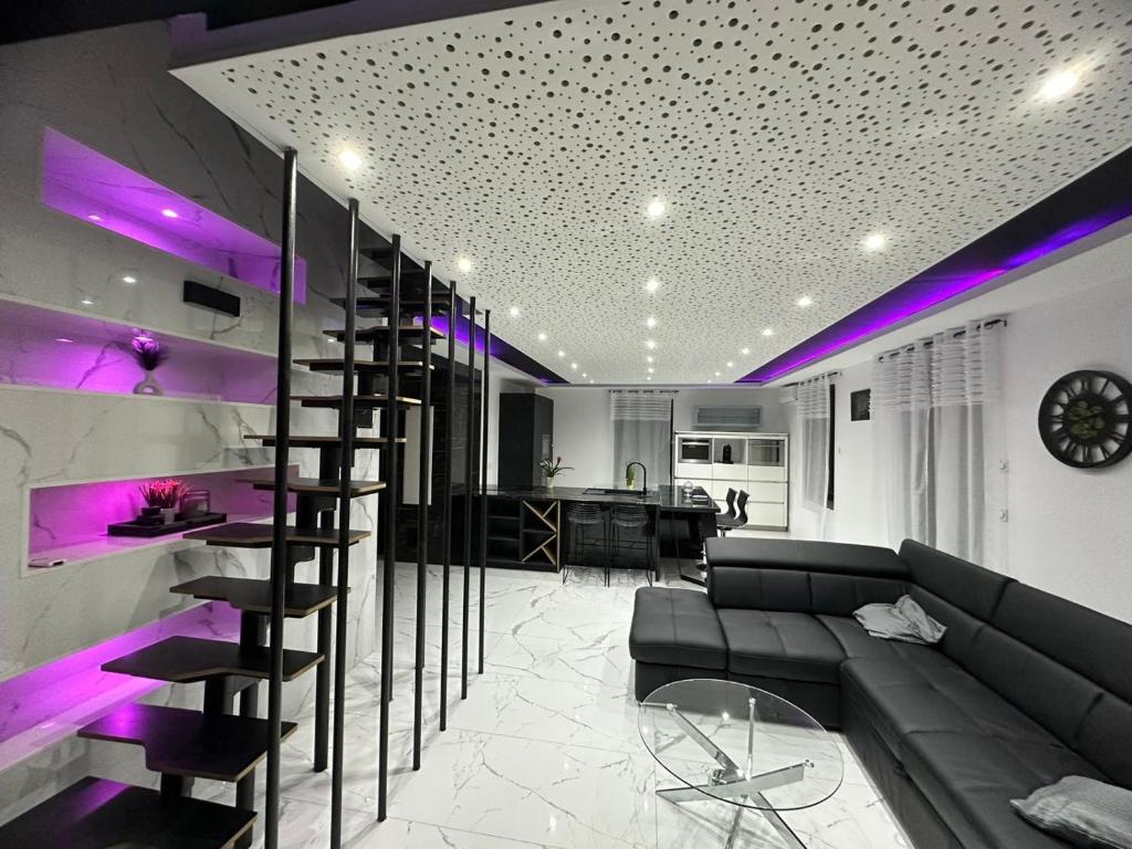una sala de estar con sofá y un bar con luces moradas en T4 TRES HAUT STANDING 130 mètres carré 